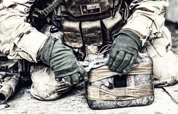 Солдат перерезает провод на самодельном взрывном устройстве
