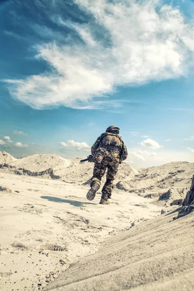 Mann in Militäruniform spielt Airsoft im Sand — Stockfoto
