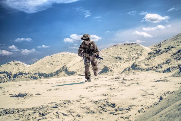 Ο άνθρωπος σε στρατιωτική στολή παίζει airsoft στην άμμο — Φωτογραφία Αρχείου