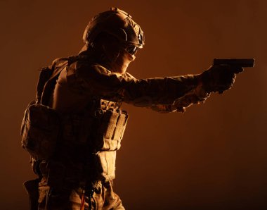 Asker ordusu elit güçler, özel güvenlik hizmeti savaşçı arkasında gizli maske ve gözlük yüz, kask ve yük taşıma sistemi, hedef hizmet tabanca düşük anahtar, yan görünüm, stüdyo çekimi ile