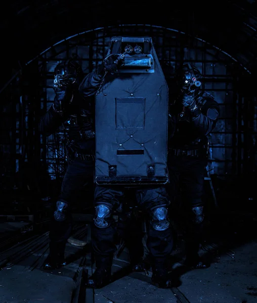 Membri della squadra SWAT che coprono con scudo balistico Foto Stock