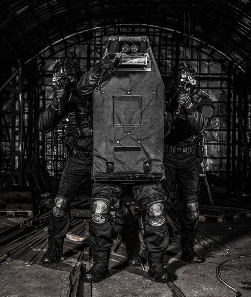 Membros da equipe SWAT cobrindo com escudo balístico Imagens Royalty-Free