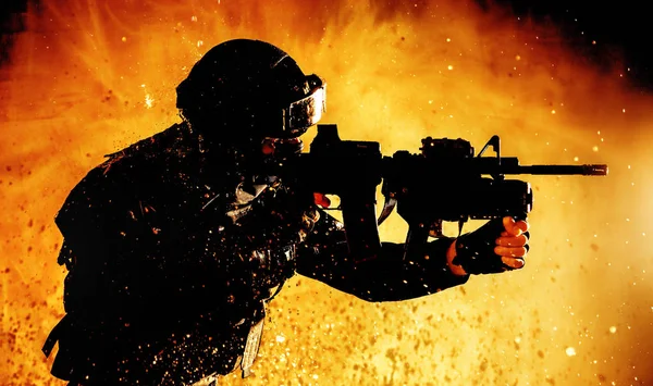 Soldado com tiro de espingarda em fundo ardente — Fotografia de Stock