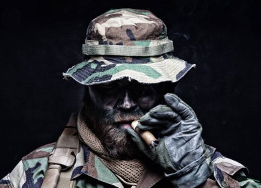 Commando soldier in boonie hat smoking cigar clipart