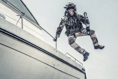 Komando avcı uçağı sürat teknesinden kıyıya iniyor.