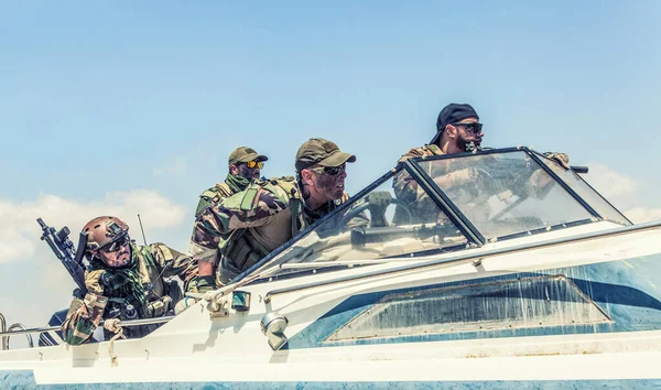 Navy SEALs team fighters rushing on speed boat