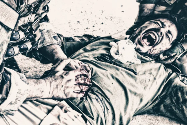 Солдаты пытаются спасти жизнь раненого товарища — стоковое фото