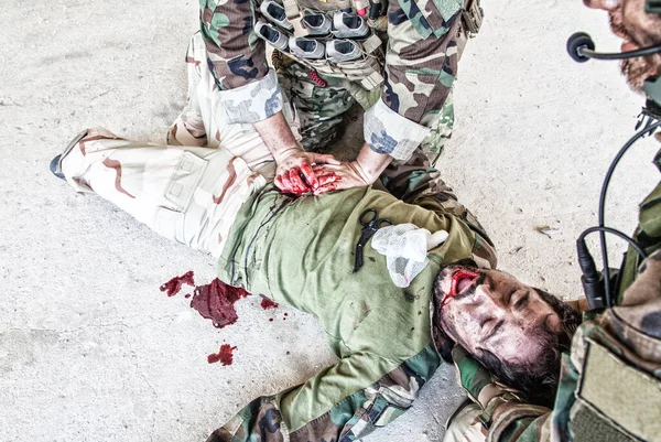 Солдат, оказывающий неотложную помощь раненому товарищу — стоковое фото