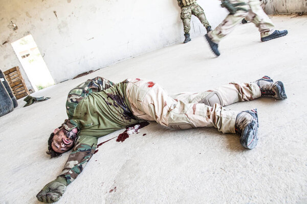 Мертвый или раненый солдат лежит на полу в крови