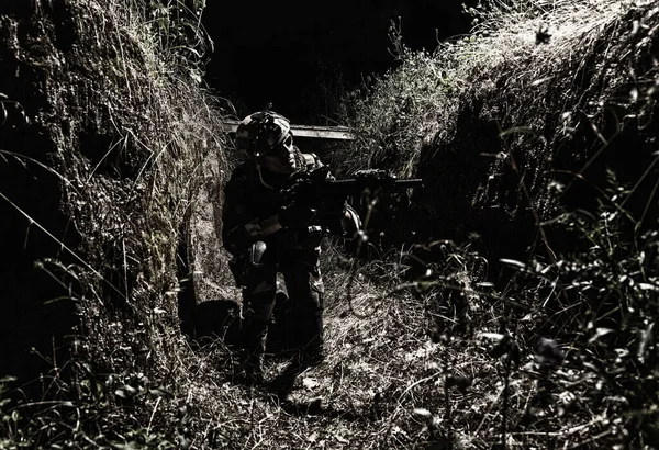Combatiente escondido del fuego enemigo en trinchera — Foto de Stock