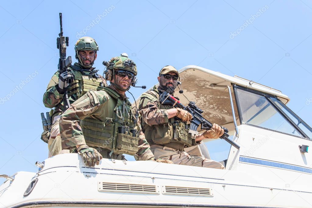 Army special forces soldiers on speed boat stern