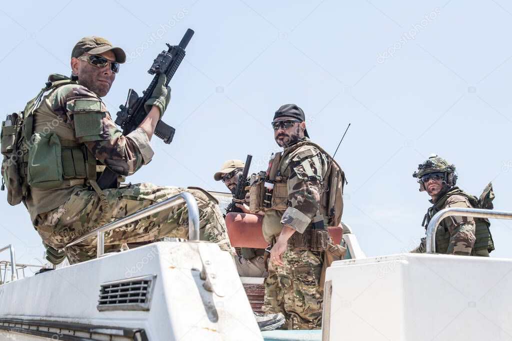 Army special forces soldiers on speed boat stern