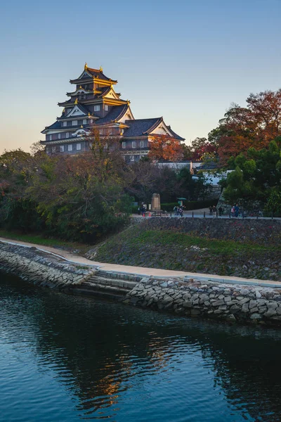 Okayama Castle by river asahi in japan at dusk