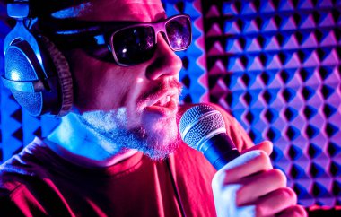 Kayıt stüdyosu olarak bir mikrofon ile şarkıcı söylüyor. Modern arka plan