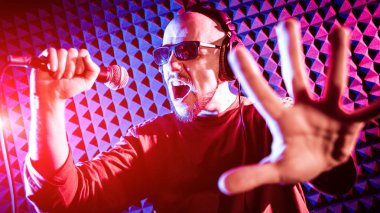 Kayıt stüdyosu olarak bir mikrofon ile şarkıcı söylüyor. Modern arka plan