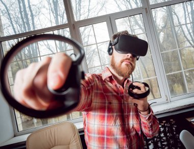 Sanal gerçeklik giyen genç sakallı adam ofiste gözlükler