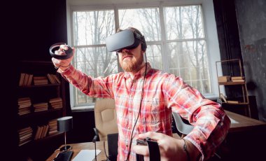 Sanal gerçeklik giyen genç sakallı adam ofiste gözlükler