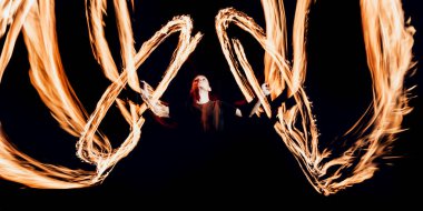 Gösteri yangın. Karanlıkta ateş performans gösteren genç adam.