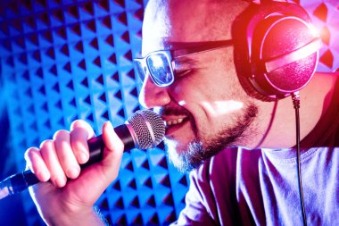 Kayıt stüdyosu olarak bir mikrofon ile şarkıcı söylüyor. Modern arka plan