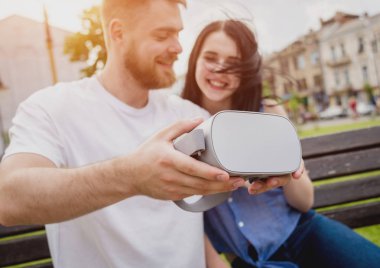 Genç çift sanal gerçeklik gözlükle sokakta bir oyun oynuyor. VR kulaklık.