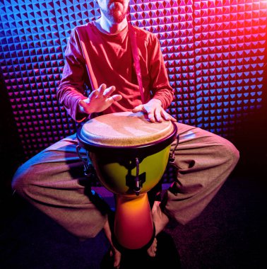 Genç adam djembe ses kayıt stüdyosu içinde oynamaya. Afrika davul