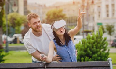 Genç çift sanal gerçeklik gözlükle sokakta bir oyun oynuyor. VR kulaklık.