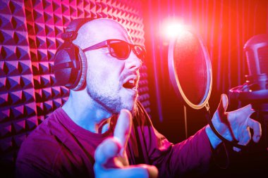 Kayıt stüdyosu olarak bir mikrofon ile şarkıcı söylüyor. Modern arka plan