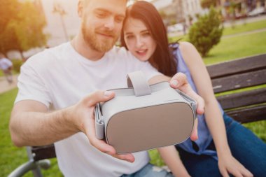 Genç çift sanal gerçeklik gözlükle sokakta bir oyun oynuyor. VR kulaklık.