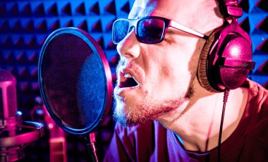 Kayıt stüdyosu olarak bir mikrofon ile şarkıcı söylüyor. Modern arka plan