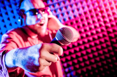 Kayıt stüdyosu olarak bir mikrofon ile şarkıcı söylüyor. Modern arka plan