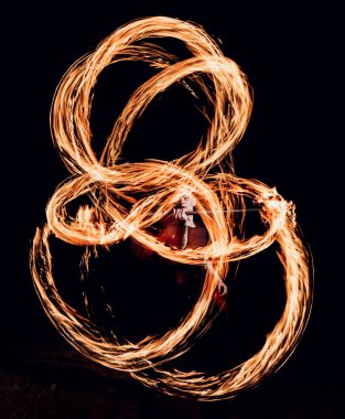 Gösteri yangın. Karanlıkta ateş performans gösteren genç adam.