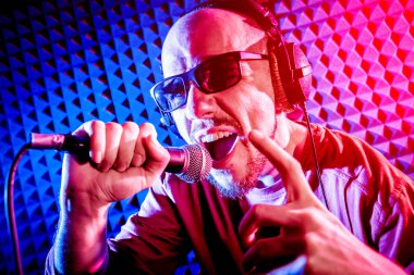 Kayıt stüdyosu olarak bir mikrofon ile şarkıcı söylüyor. Modern arka plan