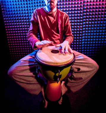 Genç adam djembe ses kayıt stüdyosu içinde oynamaya. Afrika davul