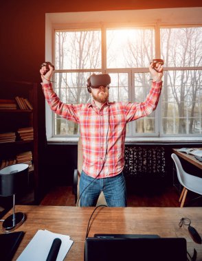 Sanal gerçeklik giyen genç sakallı adam ofiste gözlükler