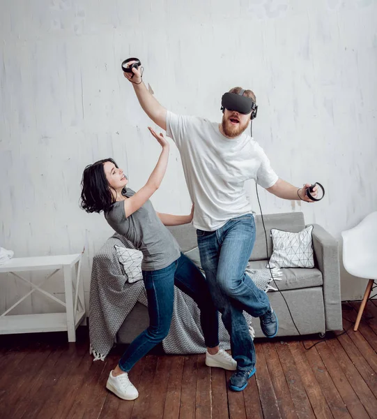 年轻男子与女朋友玩游戏与虚拟现实护目镜在家里 — 图库照片