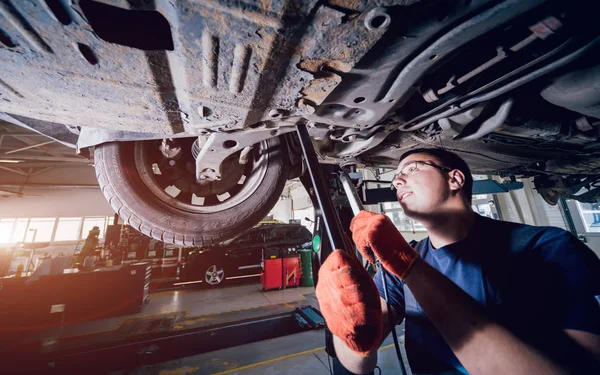 Mecánico Automóviles Examinando Suspensión Del Automóvil Levantado Estación Servicio Reparación — Foto de Stock
