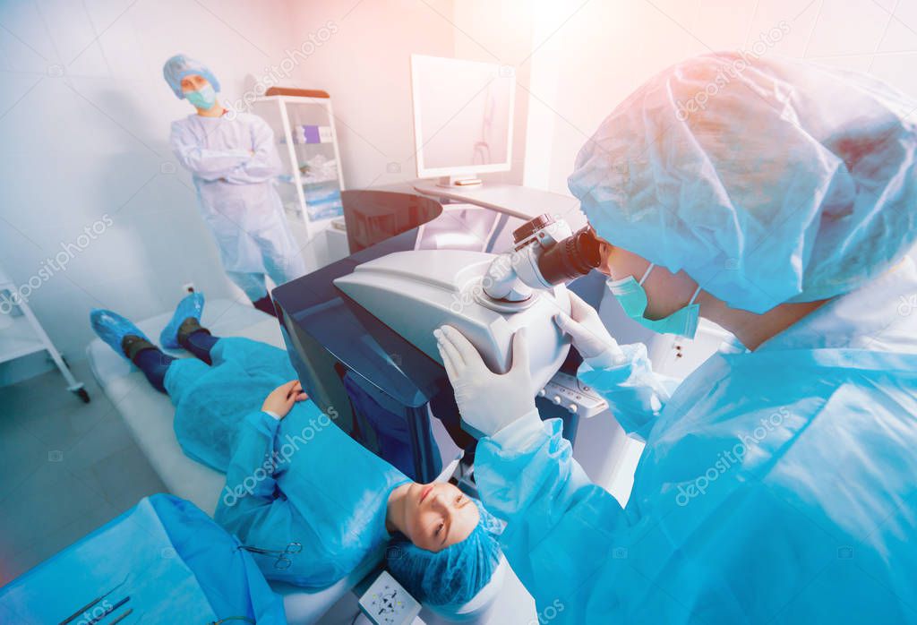 patient and team of surgeons in operating room during ophthalmic surgery