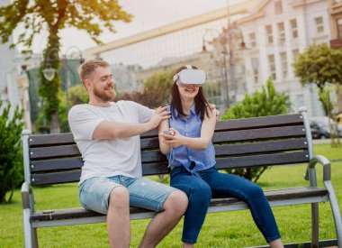 Genç çift sanal gerçeklik gözlükle sokakta bir oyun oynuyor. VR kulaklık.