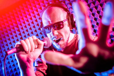 Kayıt stüdyosu olarak bir mikrofon ile şarkıcı söylüyor. Modern arka plan