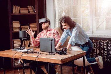 Genç adam ve kız çalış bir oyun sanal gerçeklik gözlükleri ile dolap odası. 