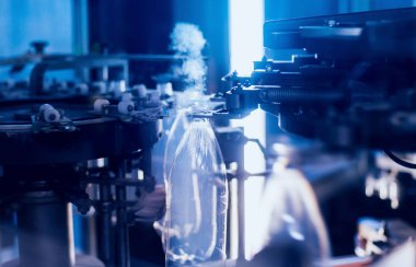 Otomatik Dolum Makinası su Plastik Pet şişe dökülen. Bira üretim. Endüstriyel arka plan.