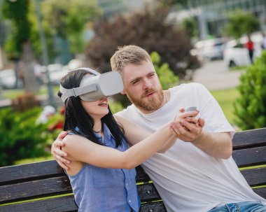 Genç çift sanal gerçeklik gözlükle sokakta bir oyun oynuyor. VR kulaklık.