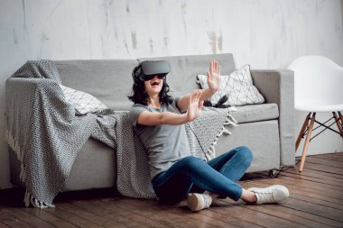 Cam kenarında oturan genç kız sanal gerçeklik giyiyor koruyucu gözlük
