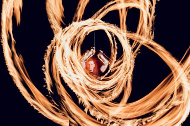 Gösteri yangın. Karanlıkta ateş performans gösteren genç adam.