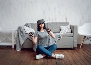 Genç kız ile sanal gerçeklik koruyucu gözlük evde oyun oynarken. VR teknolojileri