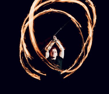 Gösteri yangın. Karanlıkta ateş performans gösteren genç adam.