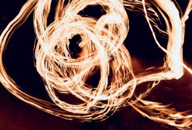 Gösteri yangın. Karanlıkta ateş performans gösteren genç adam.