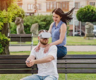 Genç çift sanal gerçeklik gözlükle sokakta bir oyun oynuyor. VR kulaklık.