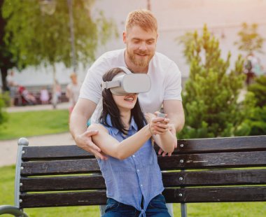 Genç çift sanal gerçeklik gözlükle sokakta bir oyun oynuyor. VR kulaklık.