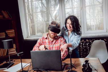 Genç adam ve kız çalış bir oyun sanal gerçeklik gözlükleri ile dolap odası. 